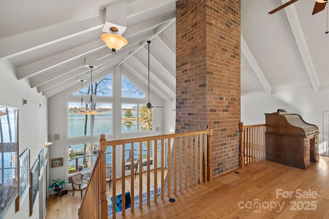 hall featuring a water view, vaulted ceiling with beams, a notable chandelier, and light hardwood / wood-style flooring