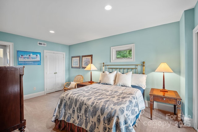 bedroom featuring a closet and light colored carpet