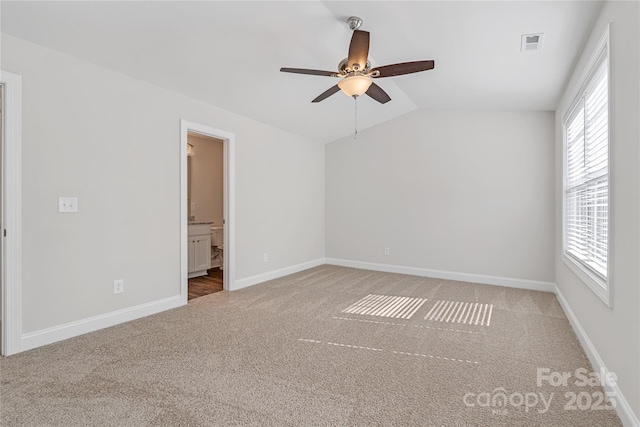 carpeted spare room featuring ceiling fan and lofted ceiling