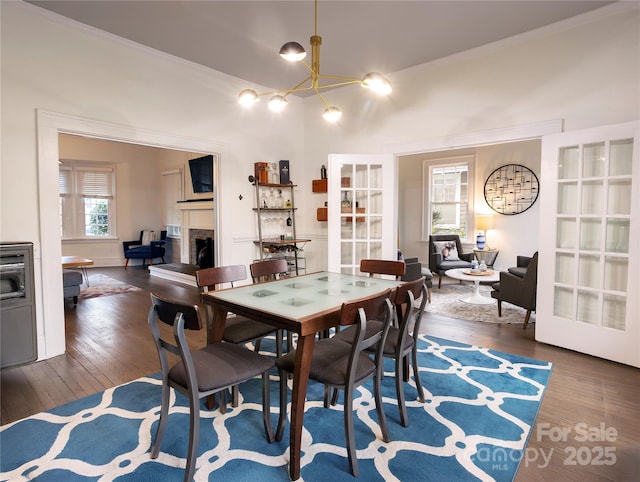 dining room with ornamental molding, dark hardwood / wood-style floors, and a notable chandelier