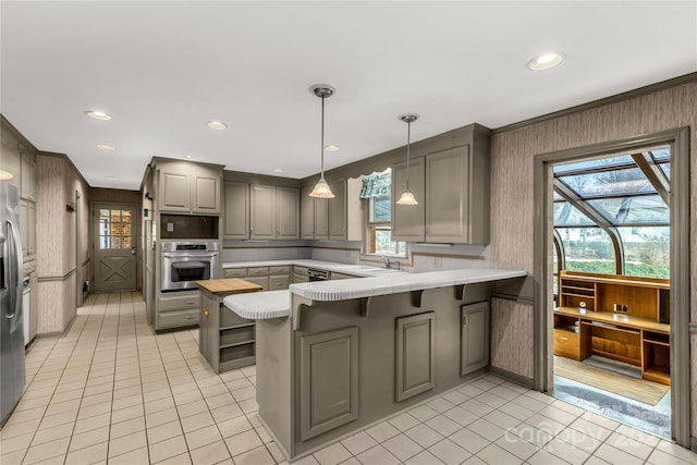 kitchen with light tile patterned flooring, a breakfast bar area, appliances with stainless steel finishes, gray cabinets, and kitchen peninsula