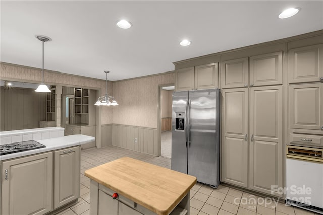 kitchen with stovetop, stainless steel fridge with ice dispenser, light tile patterned floors, a kitchen island, and pendant lighting