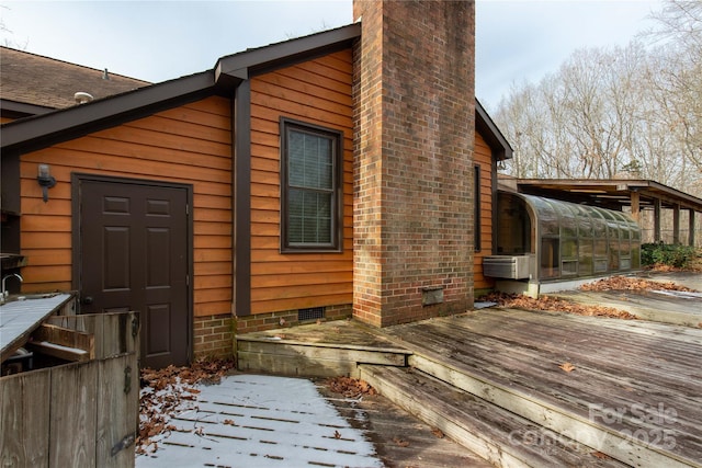 view of snowy exterior featuring a deck and a sunroom