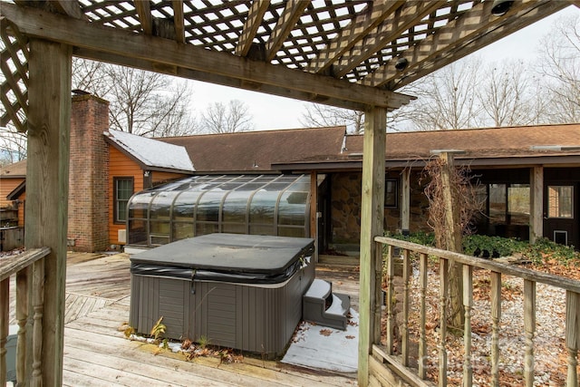 deck with a hot tub and a sunroom