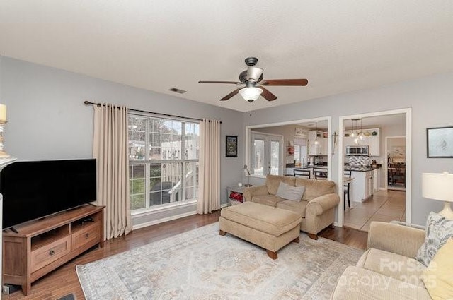 living room with ceiling fan and light hardwood / wood-style flooring