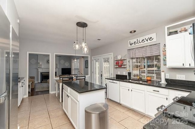 kitchen with decorative light fixtures, white cabinetry, sink, a center island, and white dishwasher