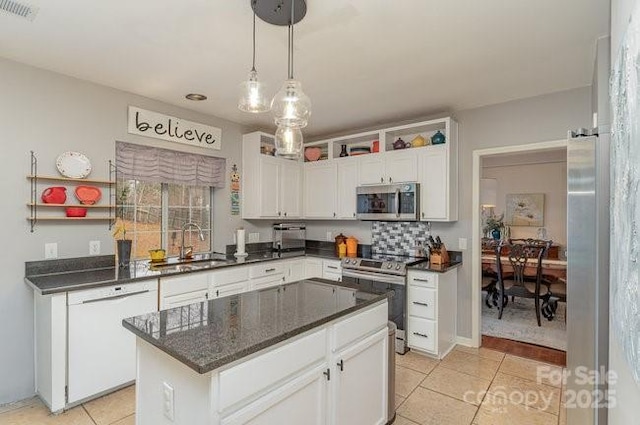 kitchen featuring sink, white cabinetry, a center island, hanging light fixtures, and appliances with stainless steel finishes