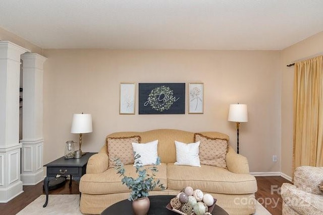 living room with decorative columns and hardwood / wood-style flooring