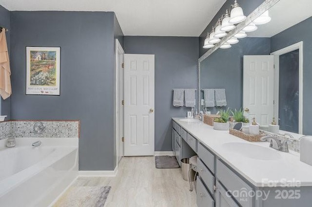 bathroom with vanity, a tub to relax in, and hardwood / wood-style floors