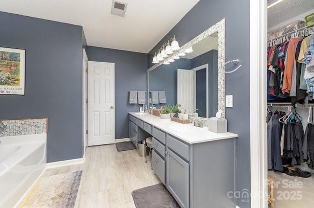 bathroom with hardwood / wood-style floors, vanity, and a washtub