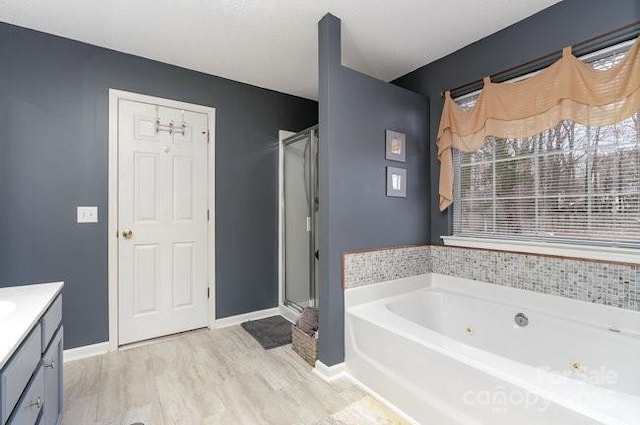 bathroom featuring hardwood / wood-style flooring, vanity, and separate shower and tub