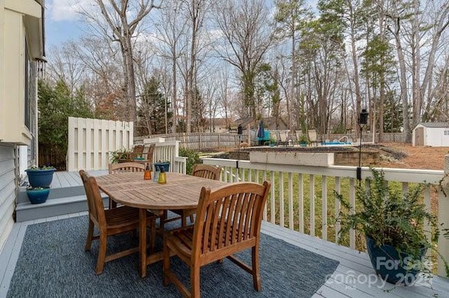 wooden deck featuring a swimming pool and a storage unit