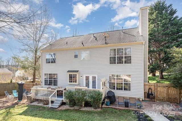 rear view of property featuring a patio area, a lawn, and a deck