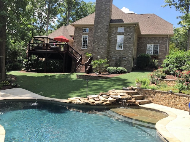 rear view of property featuring a pool side deck, a gazebo, and a lawn