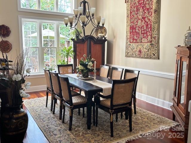 dining area featuring an inviting chandelier and hardwood / wood-style floors