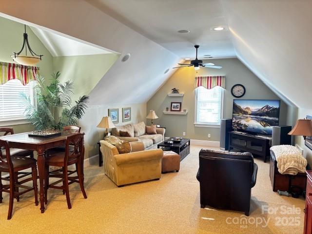 living room featuring ceiling fan, carpet floors, and lofted ceiling