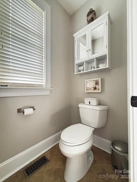 bathroom featuring toilet, plenty of natural light, and tile patterned floors