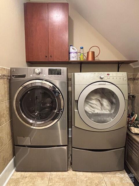 washroom featuring washing machine and dryer and light tile patterned floors