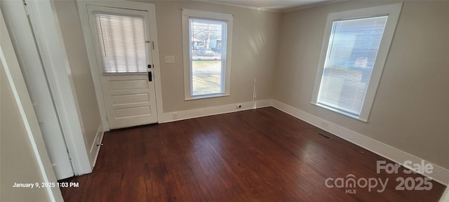 doorway with dark wood-type flooring and ornamental molding