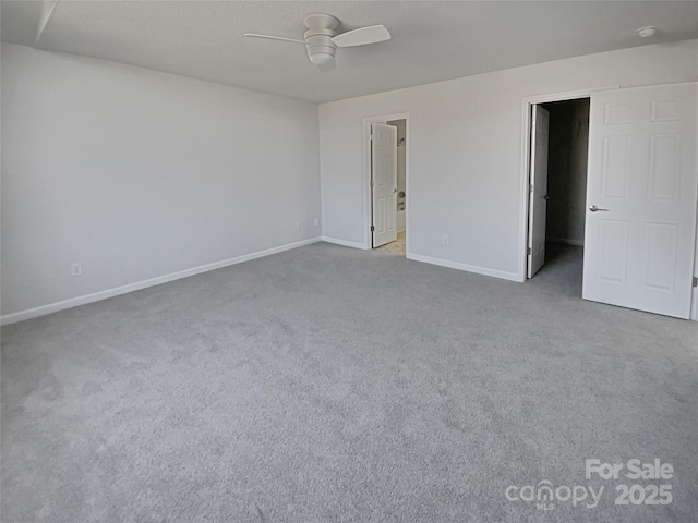 unfurnished room with ceiling fan and carpet