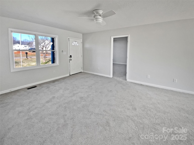 unfurnished living room featuring ceiling fan and carpet