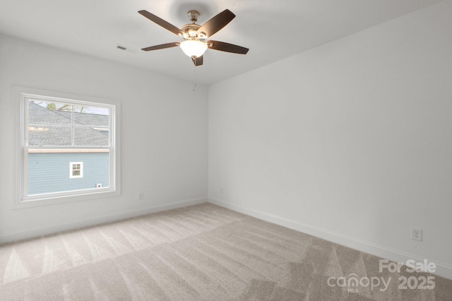 spare room with visible vents, baseboards, carpet flooring, and ceiling fan