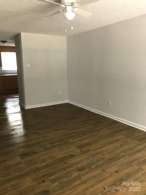 unfurnished room with a textured ceiling, ceiling fan, and dark hardwood / wood-style floors