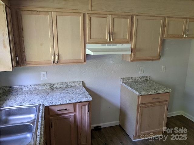 kitchen with light stone countertops, light brown cabinetry, dark hardwood / wood-style floors, and sink