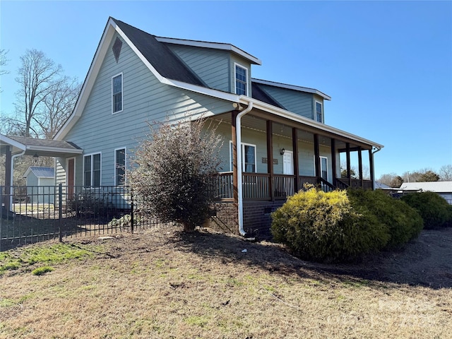 view of side of property with a porch and a yard