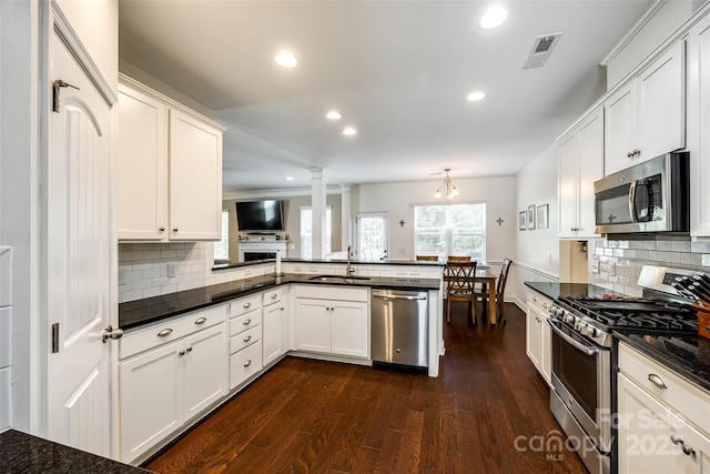 kitchen featuring white cabinets, kitchen peninsula, appliances with stainless steel finishes, and sink