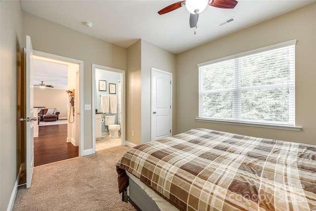 bedroom with ceiling fan, multiple windows, carpet floors, and ensuite bath