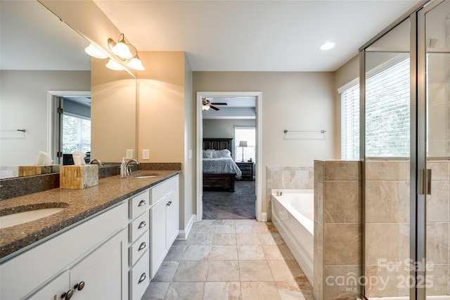 bathroom featuring vanity, separate shower and tub, and a healthy amount of sunlight