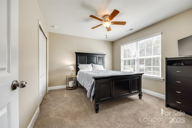 carpeted bedroom featuring ceiling fan and a closet