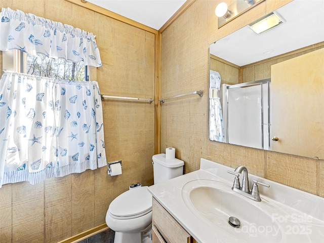 bathroom with an enclosed shower, vanity, and toilet