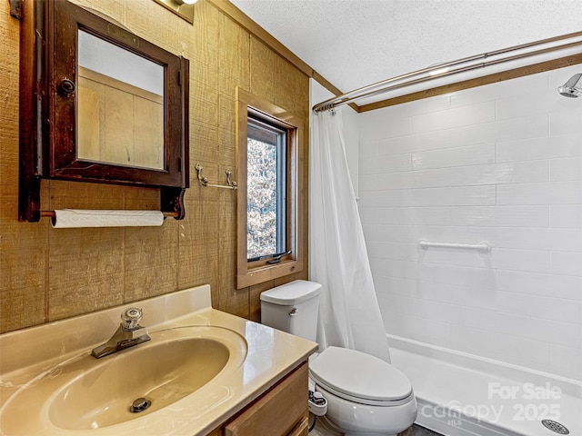 bathroom with vanity, a shower with curtain, toilet, and a textured ceiling