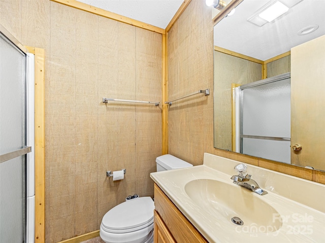 bathroom with vanity, toilet, and a shower with shower door