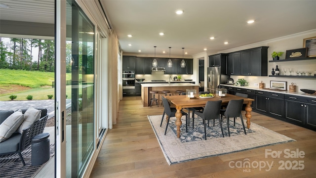 dining room featuring light wood-style floors, recessed lighting, and ornamental molding