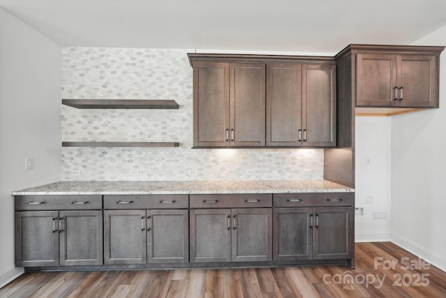 604 Hyder Trl, Tega Cay, SC 29708 - kitchen featuring wood finished floors, baseboards, decorative backsplash, light stone counters, and dark brown cabinetry