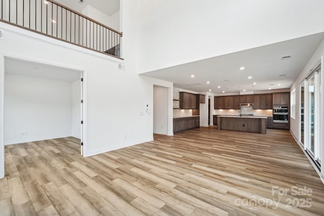 604 Hyder Trl, Tega Cay, SC 29708 - unfurnished living room featuring light wood-style floors, recessed lighting, and baseboards
