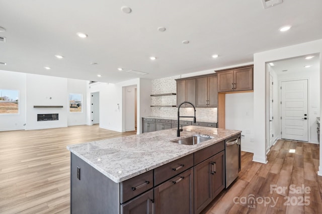 604 Hyder Trl, Tega Cay, SC 29708 - kitchen featuring light wood-style floors, dishwasher, open shelves, backsplash, and light stone counters