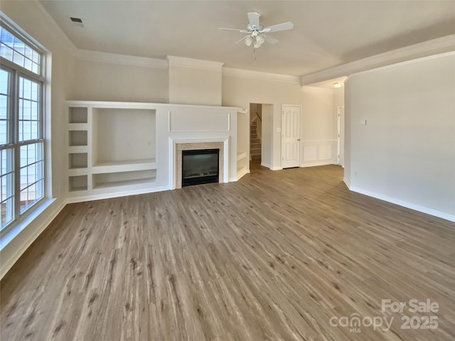 unfurnished living room with hardwood / wood-style flooring, crown molding, and ceiling fan