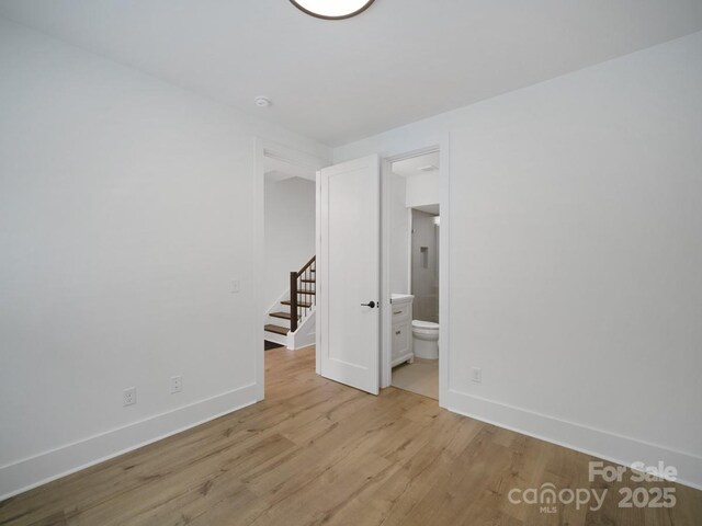2534 Weddington Ave Unit 11, Charlotte, NC 28204 - unfurnished bedroom featuring baseboards, light wood-type flooring, and ensuite bath