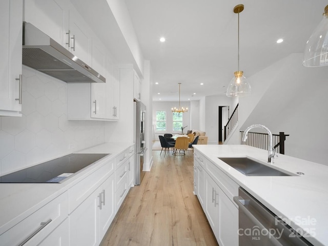 2534 Weddington Ave Unit 11, Charlotte, NC 28204 - kitchen featuring under cabinet range hood, a sink, stainless steel appliances, light wood-style floors, and white cabinetry