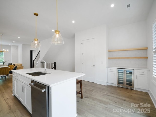 2530 Weddington Ave Unit 12, Charlotte, NC 28204 - kitchen featuring beverage cooler, stainless steel dishwasher, a sink, light wood-style flooring, and white cabinets