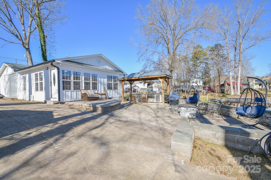 back of property featuring a gazebo and a patio area