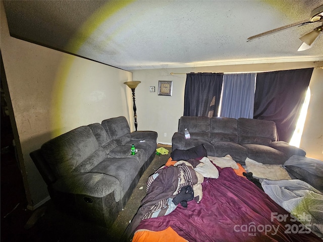 living room with ceiling fan and a textured ceiling