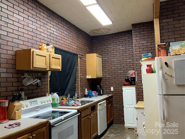 kitchen with sink, white appliances, and brick wall