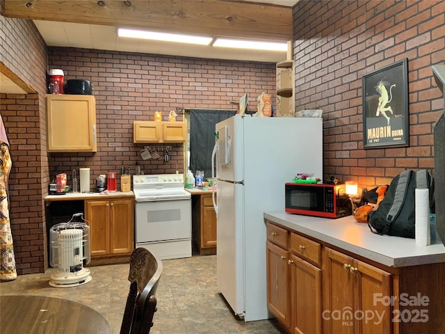 kitchen with white appliances and brick wall