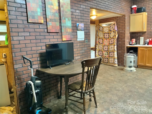 dining area with brick wall and concrete floors