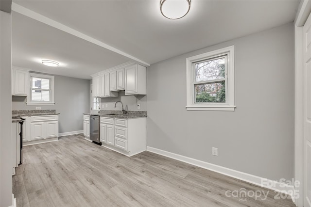 kitchen with stainless steel dishwasher, sink, light stone counters, and white cabinets